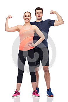 Happy sportive man and woman showing biceps power