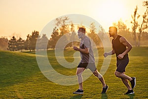 The happy sportsmen running in the beautiful park.