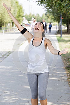 happy sportswoman with arm raised to sky