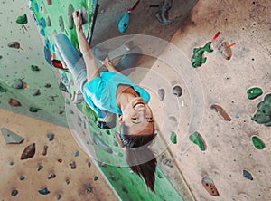 Happy sportswoman climbing indoor