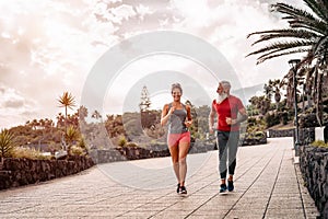 Happy sporty couple running outdoor - Fit friends jogging and training together outside