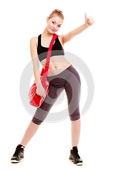 Happy sporty girl holds red gym bag ready for fitness exercise