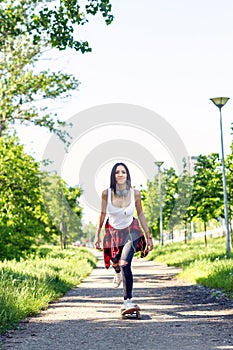 Happy sporty girl riding skateboards on street