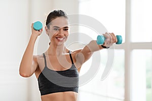 Happy Sporty Woman Exercising With Two Dumbbells And Posing