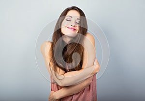 Happy sporty woman hugging herself with natural emotional enjoying face on white background. Love concept