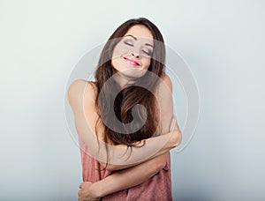 Happy sporty woman hugging herself with natural emotional enjoying face on white background. Love concept