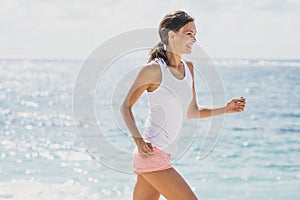 Happy sporty woman jogging with skies and sea at the background