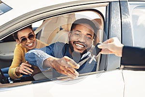 Happy Spouses Taking Key For Test Drive Sitting In Automobile