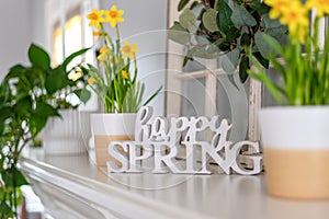 Happy Spring sign on the mantel with yellow daffodils