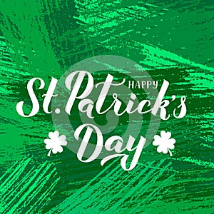 Happy St. Patrick s day calligraphy hand lettering with leaf of clover on green textured brush stroke background. Saint Patricks
