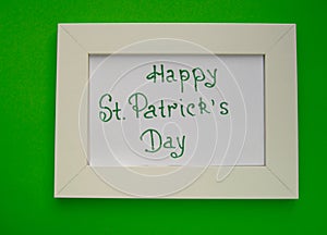 Happy St. Patrick`s Day greeting card with white frame on green background
