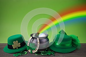 Happy St. Patrick's day. Shiny shamrocks, gold coins and leprechaun hat on a wooden background