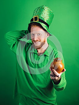 Happy St Patricks Day concept with pot of gold. Lucky charms on green background. Leprechauns hat. Man on green