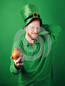 Happy St Patricks Day concept with pot of gold. Lucky charms on green background. Leprechauns hat. Man on green