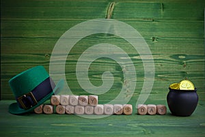 Happy St Patricks Day wooden blocks with leprechaun hat on a wooden background