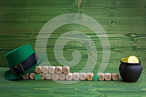 Happy St Patricks Day wooden blocks with leprechaun hat on a wooden background