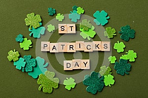 Happy St Patricks Day wooden blocks with shamrocks decor on a green background