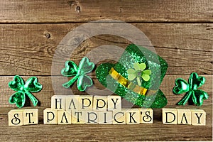 Happy St Patricks Day wooden blocks with shamrocks and leprechaun hat on a wood background