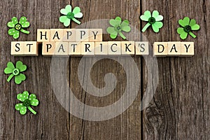 Happy St Patricks Day wooden blocks with shamrocks over wood