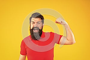 happy strong guy with beard and hairstyle on yellow background, strength