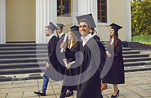 happy student boy confidently walks next to his classmates after the graduation ceremony.