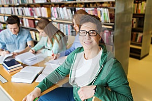 Happy student boy reading books in library