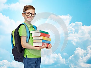 Happy student boy with school bag and books