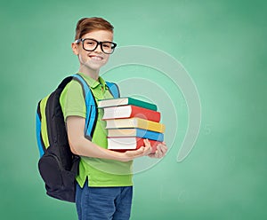 Happy student boy with school bag and books