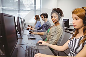 Happy student in computer class smiling at camera