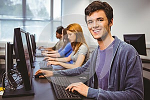 Happy student in computer class smiling at camera
