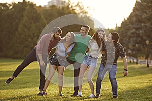 Happy student friends spending time together outdoors. Young hipsters having great time in countryside