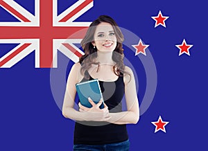Happy student girl with book against the New Zealand flag background