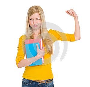 Happy student girl with book showing biceps