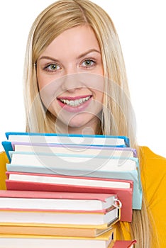 Happy student girl holding stack of books