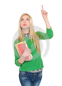 Happy student girl pointing up on copy space