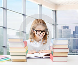 Happy student girl reading book at school