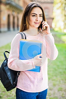 Happy student girl speaking mobile outdoors summer campus exam time