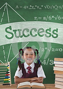 Happy student girl at table against green blackboard with success text and education and school icon