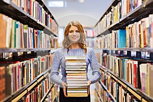 Happy student girl or woman with books in library