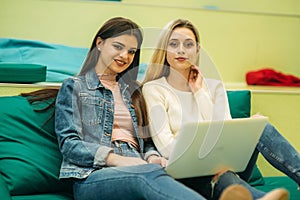 Happy student have a break in university. Have a good time while using phone , tablet and laptop. Two girls