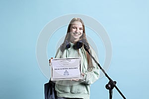 Student holding diploma talking in microphone, addressing audience photo