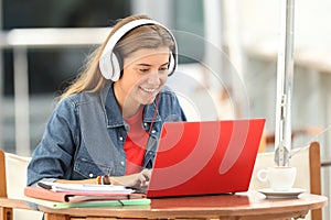 Happy student listening a video tutorial on line