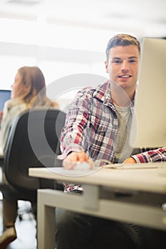 Happy student looking at camera in the computer room