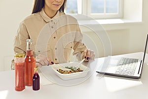 Happy student or office worker sitting at desk and enjoying healthy takeaway meal