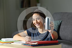 Happy student showing an energy drink can