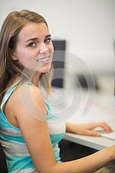 Happy student smiling at camera in the computer room