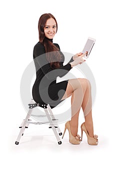 Happy student teenage girl sitting on the ladder with tablet pc