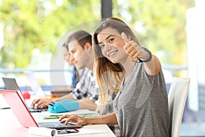 Happy student with thumbs up in a classroom