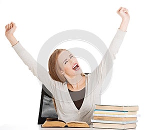 Happy student woman with her hands up and stack of books.