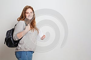 Happy student woman standing against white studio wall banner background